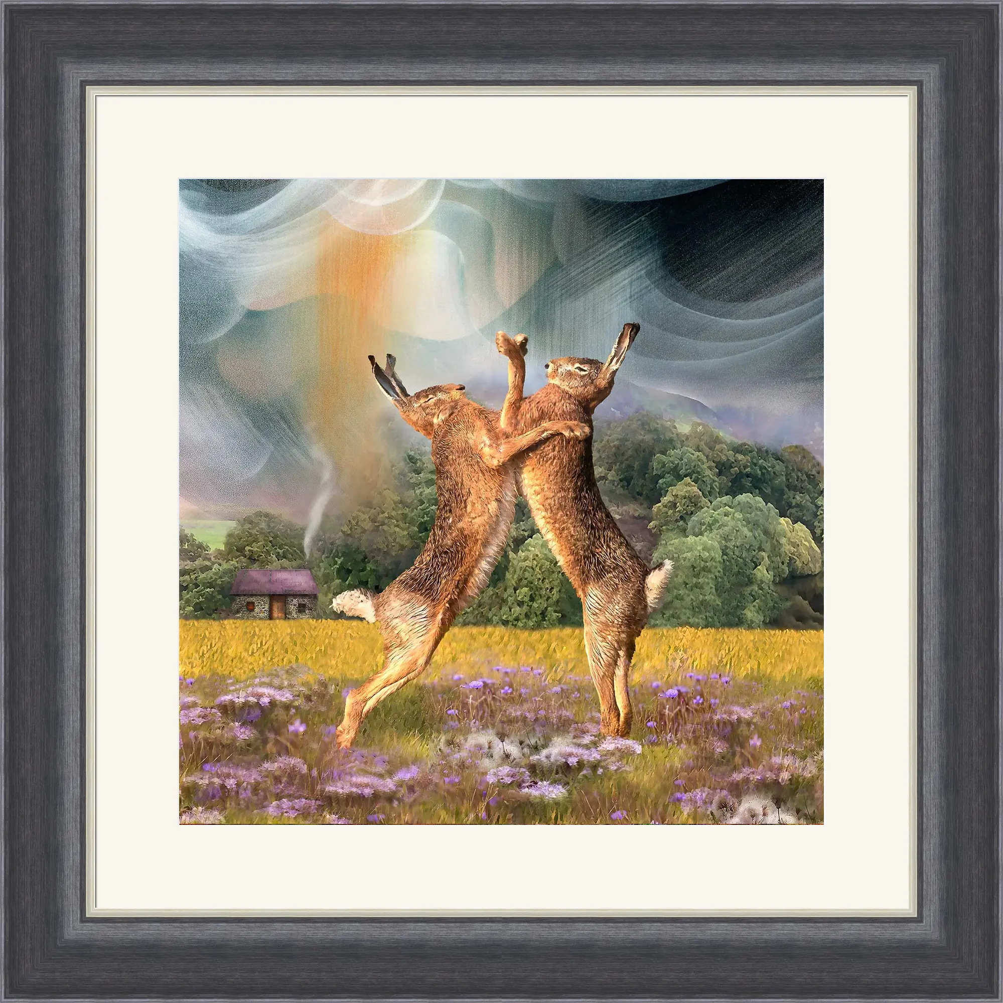 Two brown hares stand on their hind legs boxing in a wildflower meadow, with a cottage, trees, and a colourful, swirling sky in the background. The scene is framed in grey and cream.