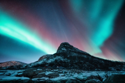 Northern lights and snowy mountains at night. Aurora borealis