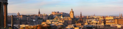 Panorama of Edinburgh at sunrise with historic skyline illuminated by early morning light